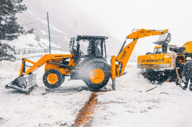 yellow and black heavy equipment on snow covered ground during daytime