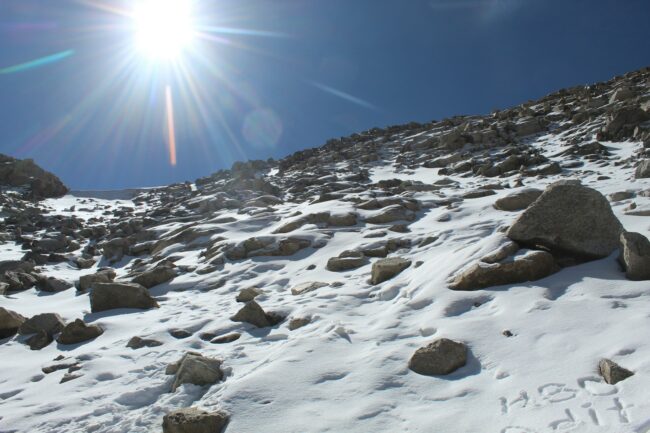 the sun shines brightly over a snow covered mountain