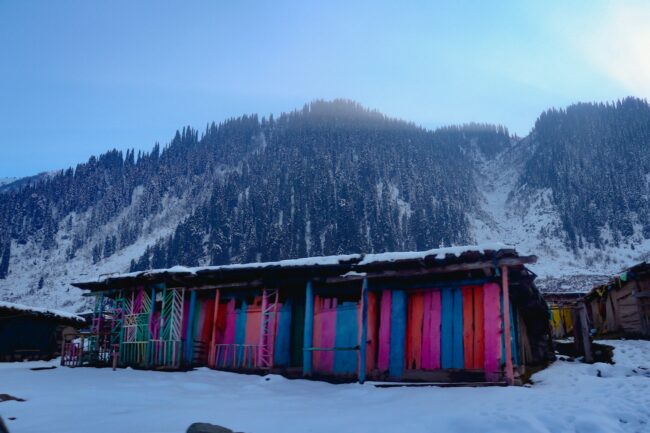 A mountain covered in snow next to a building